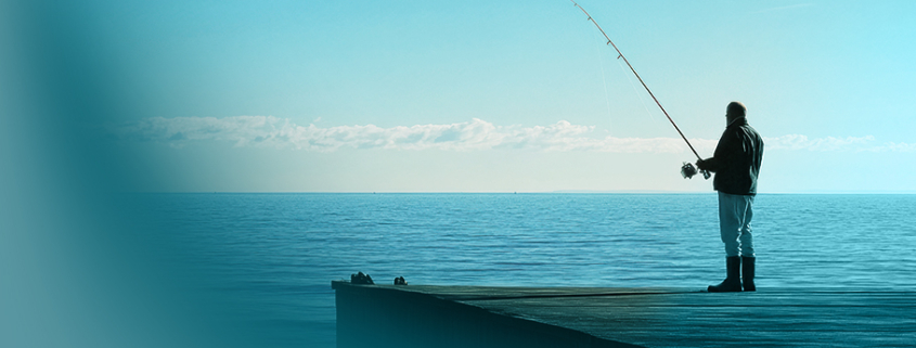 Symbolisches Bild für Blue Ocean Strategie: Einsamer Angler auf Holzsteg am ruhigen, türkisblauen Meer unter klarem Himmel – Metapher für unberührte Marktchancen.