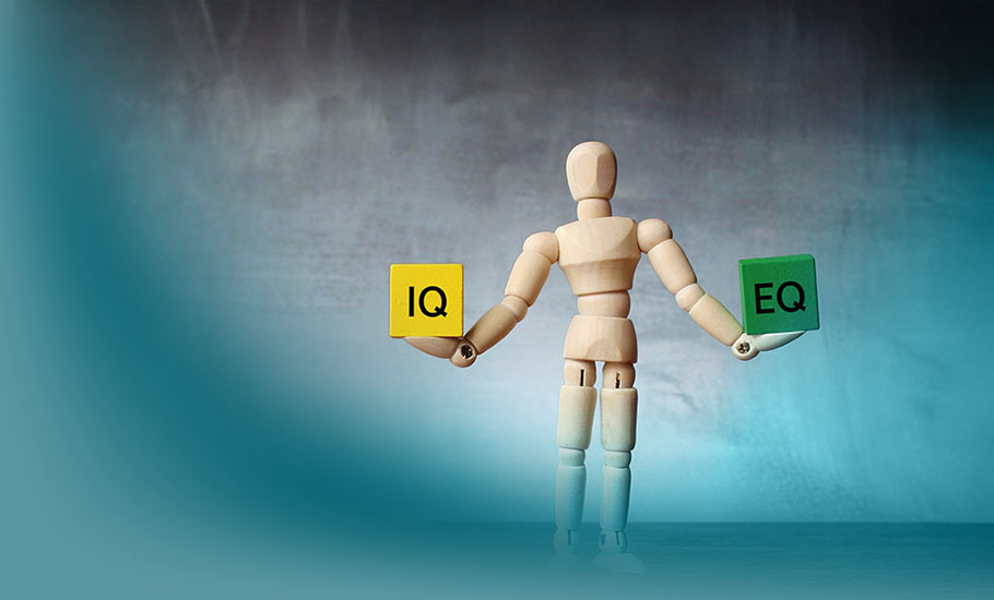 Emotionale Intelligenz: Stilisierte Holzpuppe hält gelben „IQ“- und grünen „EQ“-Würfel, symbolisiert das Gleichgewicht zwischen kognitiver und emotionaler Intelligenz.