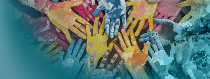 Diversität: Bunte Hände verschiedener Größen und Farben, mit Farbe bedeckt, überlappen sich in einer kreisförmigen Anordnung und symbolisieren Diversität und Inklusion.