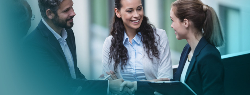 Key Account Management: Eine diverse Gruppe von Führungskräften in professioneller Business-Kleidung führt ein positives Gespräch und besiegelt ihre Vereinbarung mit einem Handschlag im Bürogebäude.