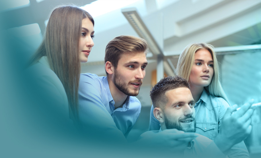 Lernen in Organisationen: Eine gemischte Gruppe junger Berufstätiger teilt Erkenntnisse am Computer – ein Sinnbild für die im Blog beschriebene Integration von Lernen in den Arbeitsalltag.