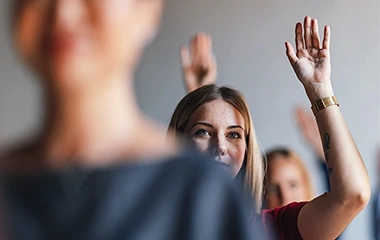 Zwei Kolleginnen heben gleichzeitig die Hände in erfolgreicher Büroatmosphäre. Erfolgreich Teams führen und entwickeln