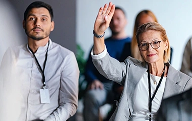 Selbstbewusste Geschäftsfrau zeigt Initiative durch Handzeichen während eines Meetings. Führen ohne Vorgesetztenfunktion