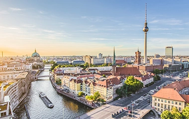 info-und-service-standorte-berlin Berlin: Luftaufnahme Berlins von der Karl-Liebknecht-Brücke mit Spree, Fernsehturm, Nikolaiviertel und Museumsinsel bei goldenem Sonnenuntergang über der historischen Stadtmitte.
