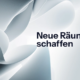 Abstrakte 3D-Skulptur auf hellem Hintergrund mit dem schwarzen Schriftzug „Neue Räume schaffen". Blue Ocean Strategie